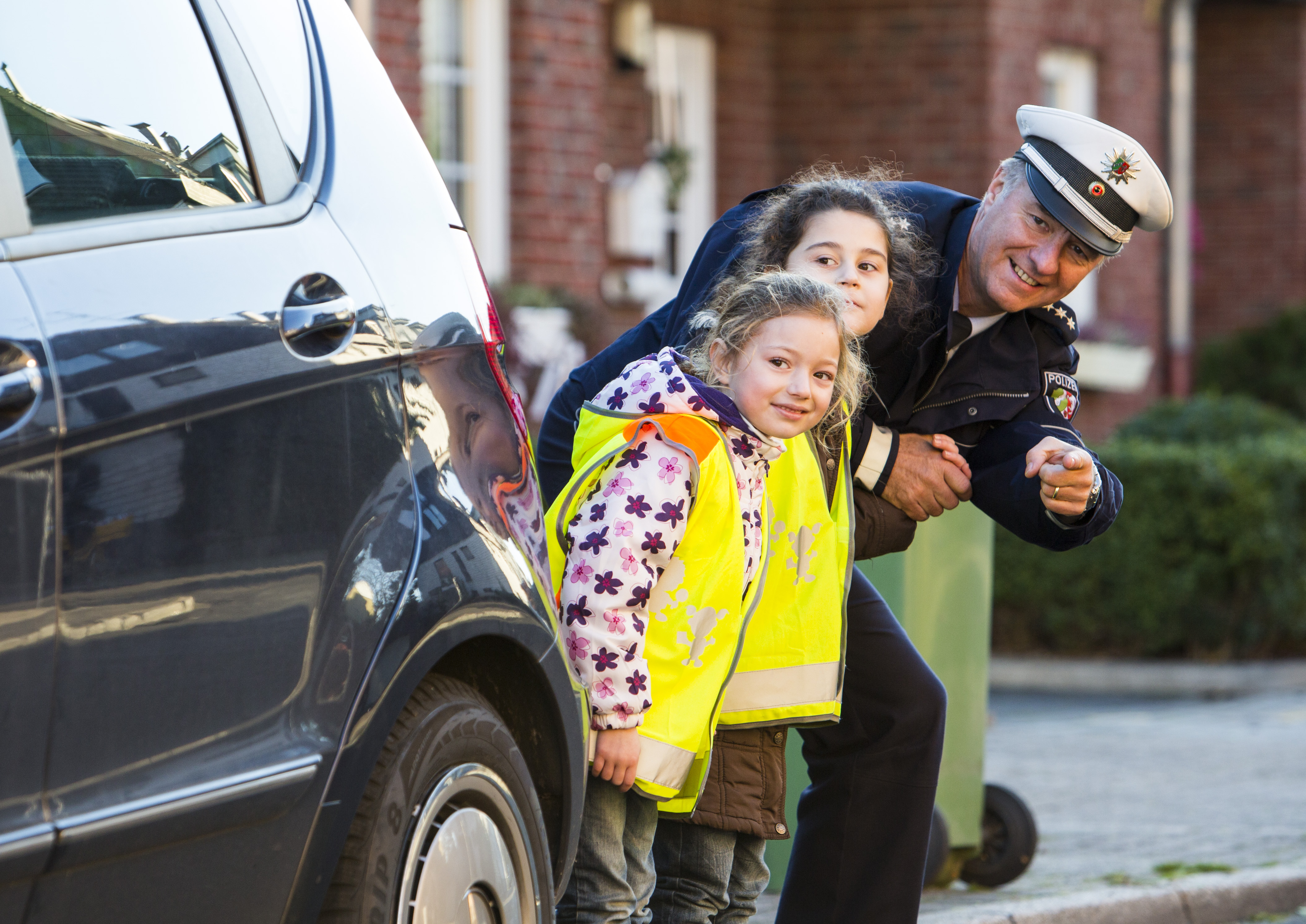 A police officer practices safe behavior in road traffic with children