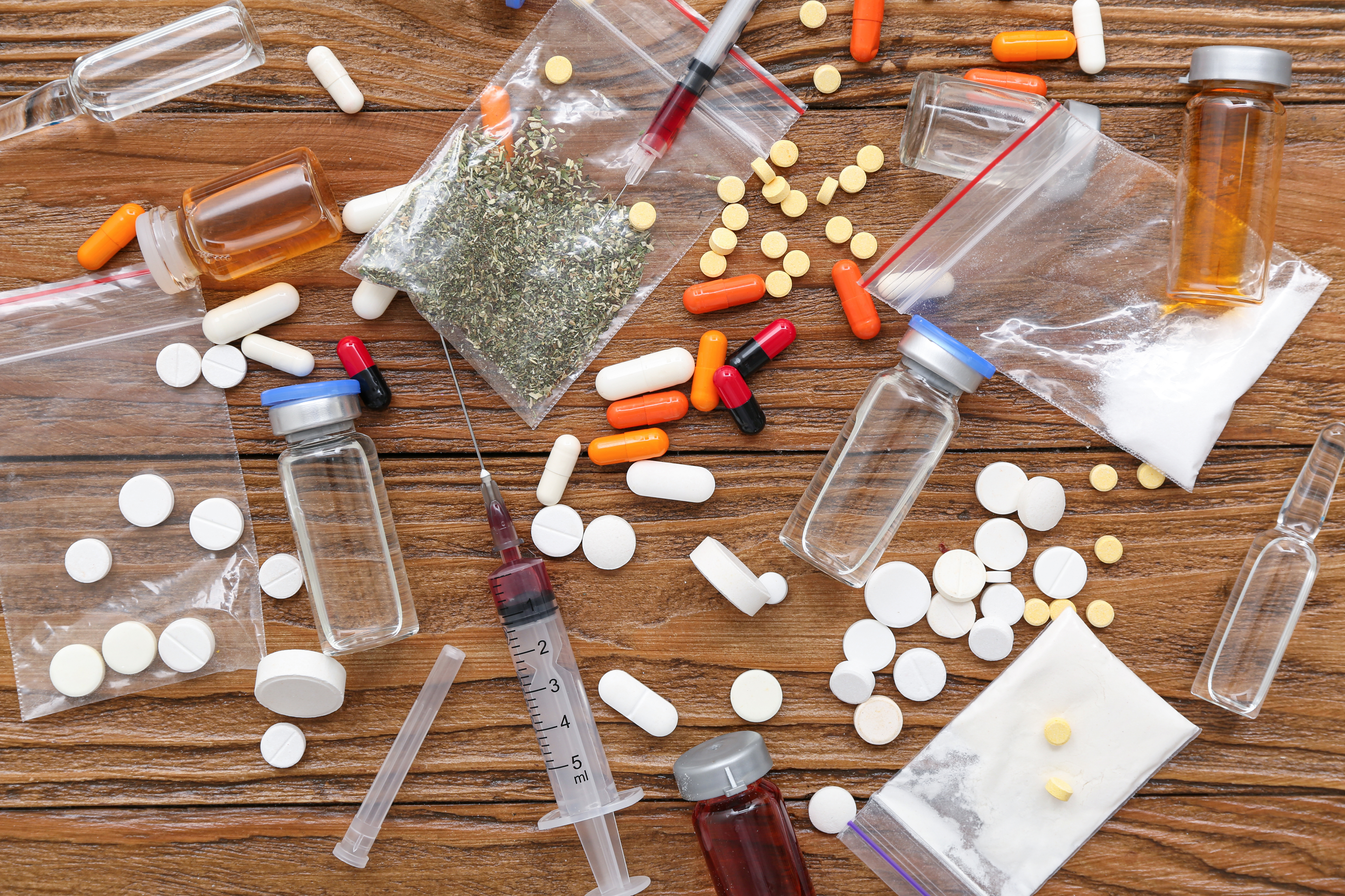 verschiedene Drogenkonsumutensilien und Betäubungsmittel wie Tabletten, Spritzen, Pulver, Pillen