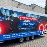 Kampagnenanhänger Verantwortung stoppt Vollgas. Man sieht einen Autoanhänger mit Plane. Auf der plane steht die Kampagnenaufschrift.