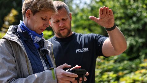 Zwei Personen schauen auf das Steuerungsgerät einer Drohne.
