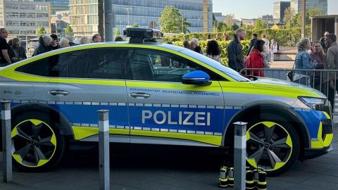 Der Streifenwagen der Zukunft, ein coloriertes Einsatzfahrzeug der Polizei NRW, steht vor dem Dienstgebäude des LKA NRW und wird von interessierten Besuchern betrachtet.
