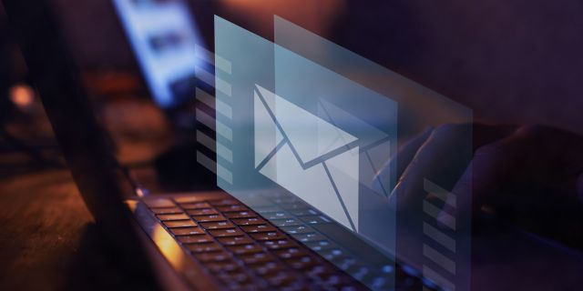 Auf einem Laptopbildschirm ist ein Briefumschlag als Zeichen für eine eingegangene Email zu sehen