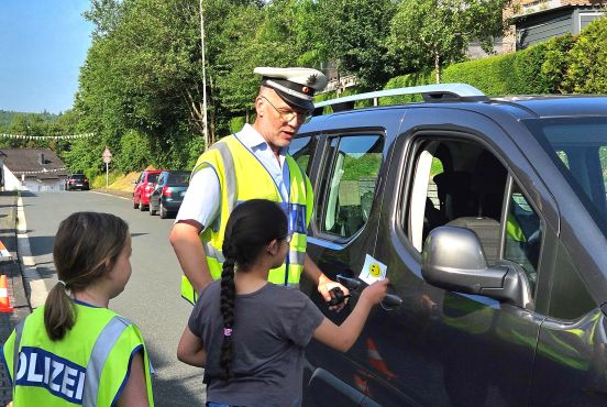 Kinder geben Dankzettel mit Polizist