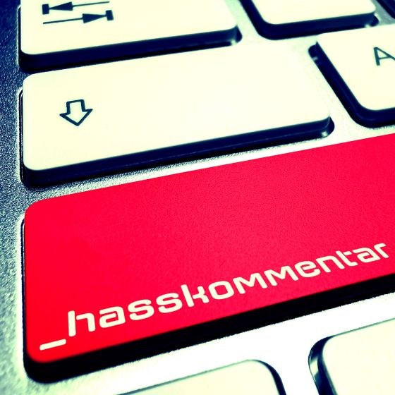 PC Tastatur mit einem roten Button und der Aufschrift Hasskommentar
