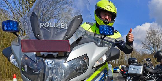 Polizist auf Motorrad Daumen hoch